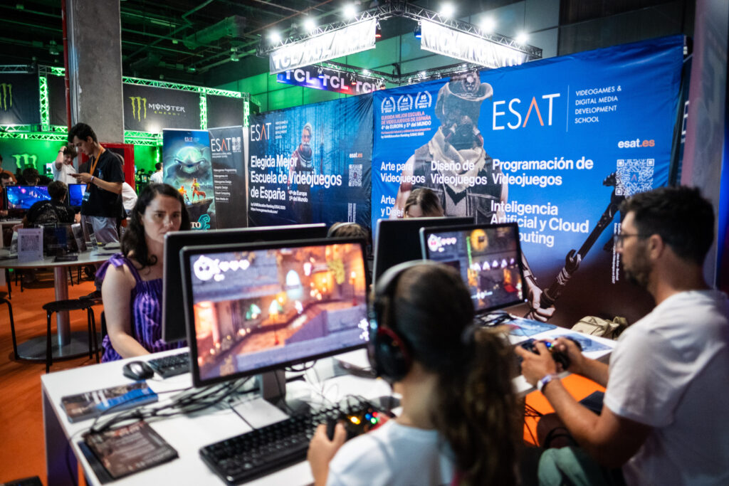 Grupo de gente probando juegos en el stand de la ESAT