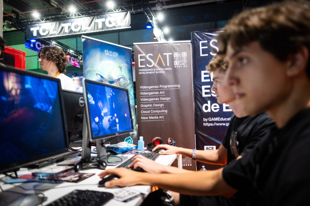 Chicos en el Stand de la ESAT probando juegos nuevos en OWN Valencia
